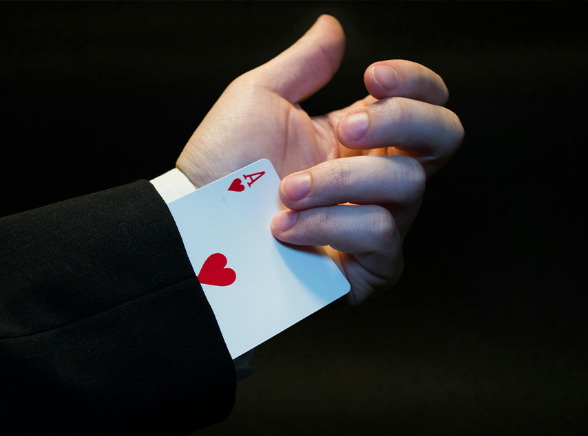 Person performing magic trick with card up their sleeve