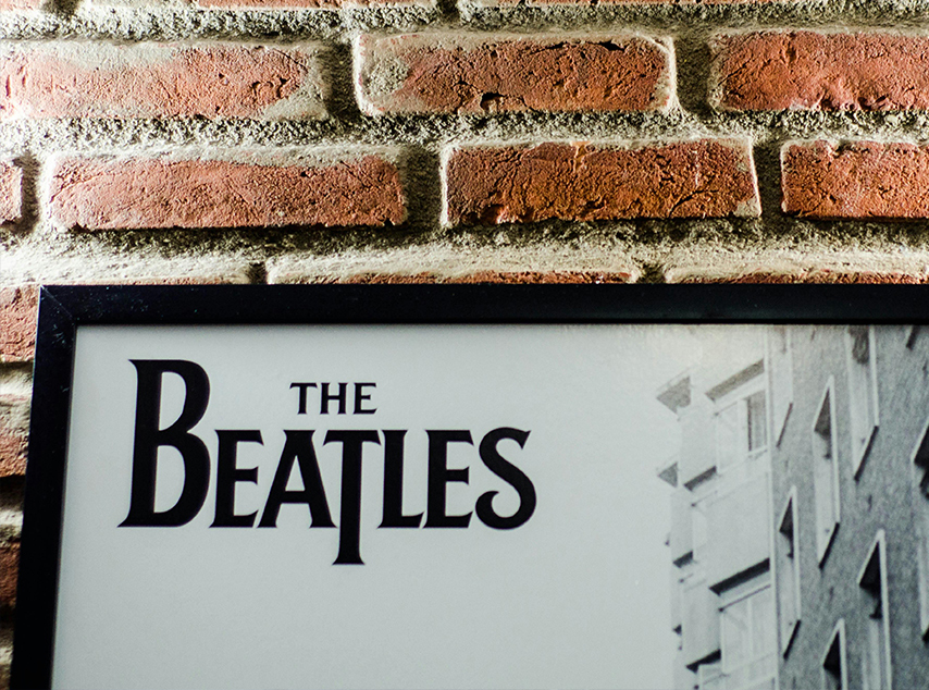 The Beatles poster on brick wall